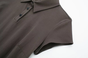 Dettaglio del colletto dell'abito polo marrone scuro con abbottonatura a tre bottoni