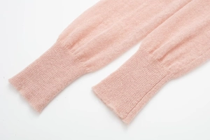 Close-up of soft pink mohair knit sweater featuring detailed ribbed cuffs and texture