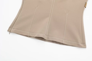 Close-up of khaki woven top with white contrast stitching and side invisible zipper
