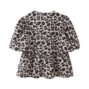 Close-up of leopard print top with puff sleeves and peplum waist on white background