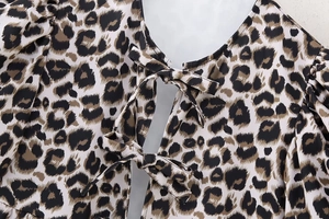 Close-up of leopard print top featuring elegant bow tie details and breathable fabric