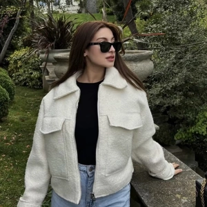 Short cream-colored bouclé jacket for women with metal zipper and large chest pockets