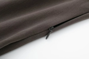 Dettaglio del tessuto in twill marrone scuro con una cerniera invisibile a scomparsa