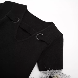 Women's black V-neck knitted dress featuring metallic ring detail and ribbed texture
