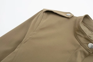 Détail de l'épaulette d'une veste kaki avec boutons-pression en argent mat