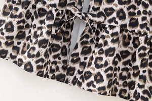 Detail of leopard print top featuring tie-up bow and delicate ruffled hem craftsmanship