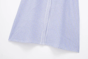 Detail view of blue and white striped seersucker fabric texture on the dress hemline
