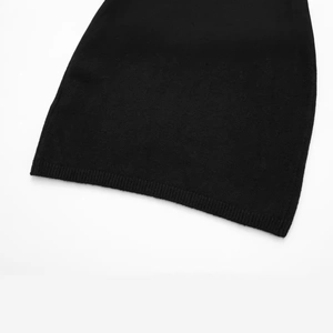 Close-up of black short sleeve knit dress featuring ribbed hem and fine texture