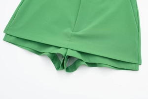 Detailed view of bright green skorts featuring clean tailoring and layered hem design