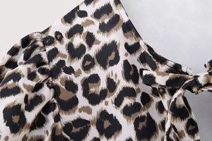 Detail shot of leopard print top featuring puff sleeves and tie-up neckline texture