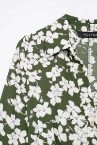 Detail of floral printed dark green dress showing shirt collar and pearl button