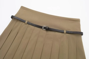Détail d'une jupe-culotte plissée kaki avec ceinture fine en cuir marron et boucle