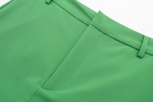 Close-up of green skirt-pants featuring belt loops and a clean tailored waistband design