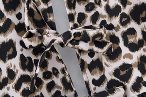 Close-up of leopard print top featuring a stylish front bow tie and detailed fabric texture