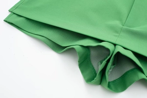 Detail of bright green skorts showing the pleated hem and inner anti-exposure mesh lining