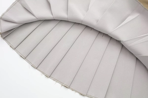 Gros plan détaillé montrant la texture plissée et les coutures sur tissu gris