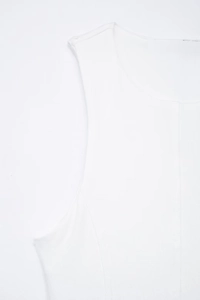 Detail shot of white sleeveless dress showing vertical ribbed texture and round neckline