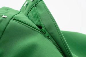 Detail of hidden zipper on grass green skirt pants with precise stitching finish
