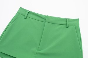 Detail view of grass green high-waisted skorts showing belt loops and side pockets