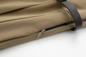 Détail en sergé kaki avec fermeture éclair invisible et accent en cuir marron de qualité