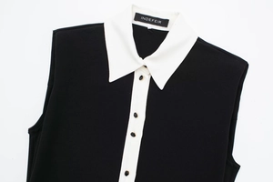 Dettaglio vestito nero senza maniche con bottoni bordo oro e colletto bianco a contrasto