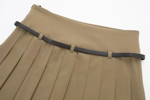 Vue détaillée de la texture d'une jupe plissée kaki avec une fine ceinture noire à la taille