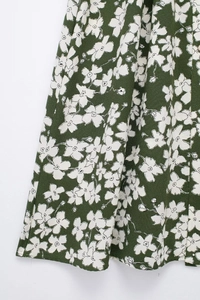 Detail of dark green floral fabric with white flower prints and light texture