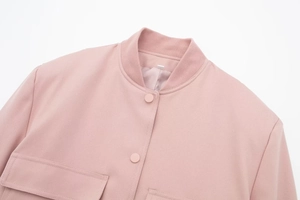 Dettaglio della giacca bomber rosa con colletto a coste, trama saia e ampie tasche