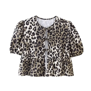 Detail of leopard print blouse featuring front tie bows, puff sleeves and ruffled hem