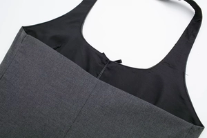 Close-up of dark grey twill fabric texture and black lining with reinforced stitching detail