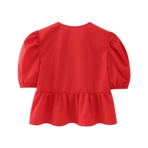 Detail view of the back of a red puff sleeve top featuring elegant ruffled hem design