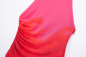 Detailed view of the side ruched texture and invisible zipper on a gradient mesh dress