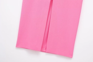 Close-up of hemline detail on bright pink dress showing split and fine stitching