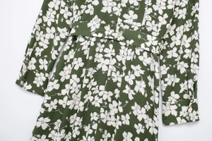 Close-up of floral print dress with waist belt and decorative cuff buttons