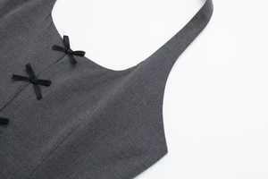 Close-up of grey halter top featuring black satin bows and twill fabric texture