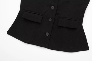 Detail of black halter vest showing single-breasted buttons and flap pocket texture