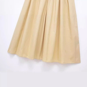 Elegant light khaki pleated dress featuring fine fabric texture and fluid drape design