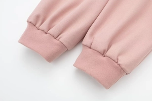 Dettaglio del polsino elastico a coste della giacca bomber rosa in maglia fitta
