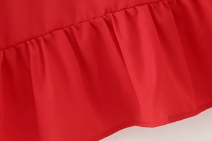 Detailed macro view of vibrant red blouse fabric showing exquisite ruffled layers and pleats