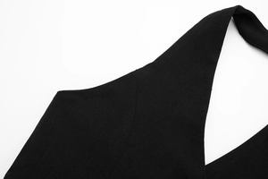 Detailed macro view of the black halter neckline design and premium woven fabric texture
