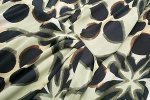 Détail du tissu à imprimé léopard avec un nœud torsadé et un petit bouton noir chic