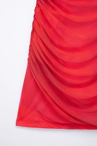 Detailed macro view of ruched red mesh fabric with fine hem stitching on a dress