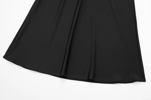 Detailed view of the smooth black satin midi skirt hemline with double needle stitching