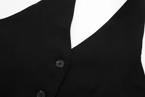 Close-up of black V-neck vest showing textured woven fabric and button details