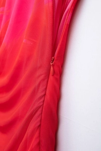 Detail of red gradient mesh dress showing a matching invisible side zipper and fabric texture