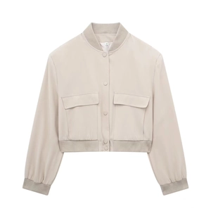 Dettaglio del bomber beige con grandi tasche utility e chiusura con bottoni a pressione