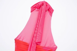 Detail of halter neck dress featuring pink and red mesh fabric with a large bow