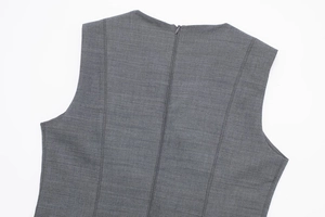 Detail view of the back invisible zipper and structured stitching on a grey sleeveless dress