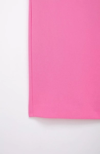 Detailed view of the peach pink dress showing precision stitching and woven fabric texture
