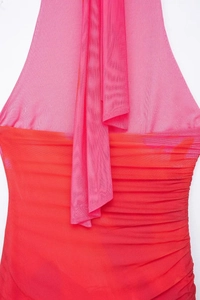 Detail of red and pink mesh halter dress featuring elegant ruching and sheer fabric texture